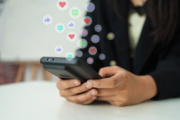 Business person using smartphone with floating social media reaction icons, representing digital marketing, online engagement, social media communication, and modern