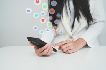 Business person using smartphone with floating social media reaction icons, representing digital marketing, online engagement, social media communication, and modern