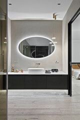 Luxury bathroom vanity unit on wooden floor in open-plan bedroom layout