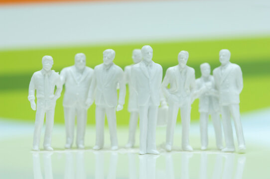 Macro shot of business figurines in suits symbolizing teamwork