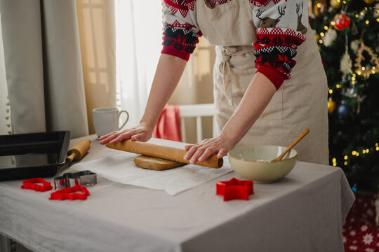 Woman baking gingerbread cookies at home for Christmas holiday