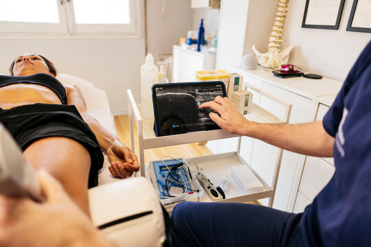 Physiotherapist performing abdominal ultrasound scan in clinic