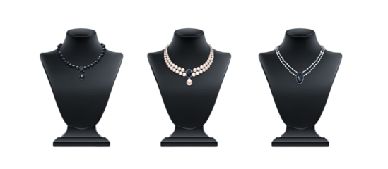 Three elegant necklaces displayed on black busts against a black background