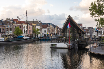 Leiden, Netherlands - 05 May 2019: View of a picturesque canal reflecting the vibrant hues of historic buildings and the modern, angular architecture of a waterfront structure.