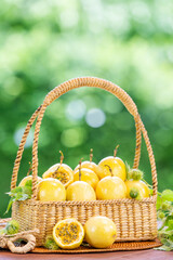 Passion fruit with leaf in basket on green nature bokeh background, Fresh Passion fruit or Maracuja in wooden table on blur background.