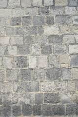 Obraz premium A full frame shot of an old rustic wall made of weathered square stone blocks in various shades of grey