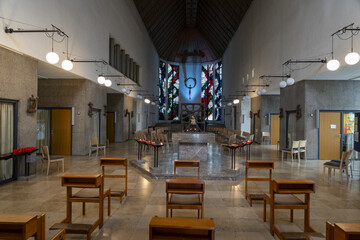 Koblenz, Germany - 17 September 2025: View of the quiet, empty church interior, with light streaming through the stained glass behind the altar, casting a gentle glow on the polished marble floors.
