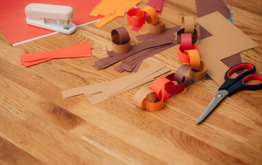 Making a paper garland with scissors, paper, and glue, creative holiday craft.