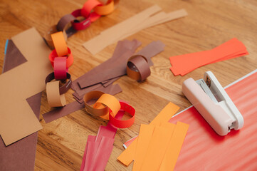 Making a paper garland with scissors, paper, and glue, creative holiday craft.