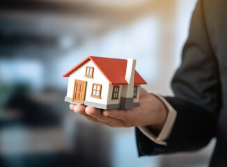 A home in the palm of an official's hand. Affordable housing. Real estate services. Housing policy...