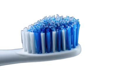 Closeup of a toothbrush head with blue and white bristles and toothpaste