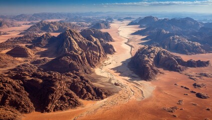 Fototapeta premium Aerial view showcasing arid landscape, with expansive desert, rugged mountains, and dry riverbed
