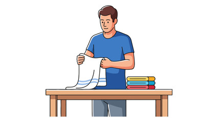 A man is folding a white towel with blue stripes on a wooden table.