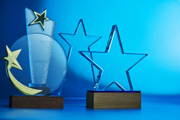 Group of star shaped crystal trophy against blue background