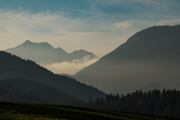 View of the serene, misty mountain range layered in shades of deep blue and green, under a soft sky, a tranquil scene, Krun, Bavaria, Germany.
