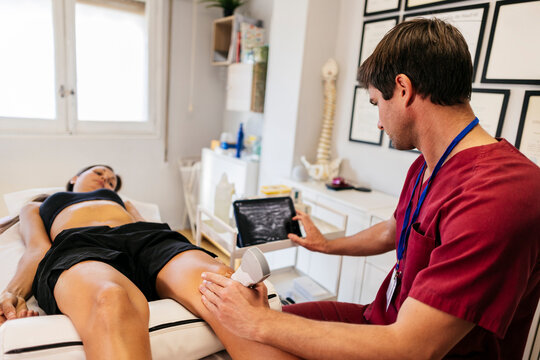 Technician performing a pelvic ultrasound examination in a clinic