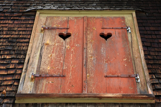 Rustic wooden window shutters with heart carvings in Kaunertal Tyrol