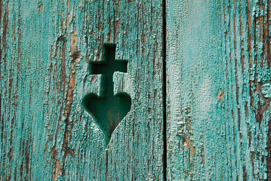 Carved cross and heart symbol in weathered painted wood Austria
