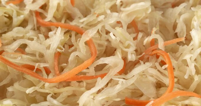 Fermented cabbage with  carrot, sauerkraut, sauer kraut, healthy vegan crunchy probiotic. Close-up footage on the rotating table.