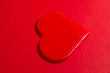 Red heart shape on a vibrant red background, signifying love and passion for Valentines Day or engagement announcement.