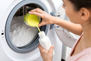 Woman pouring laundry detergent into washing machine