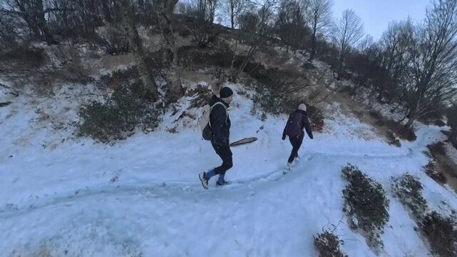 Monte Lema, Varese, Italy: couple of hikers walking on a path halfway up the snow