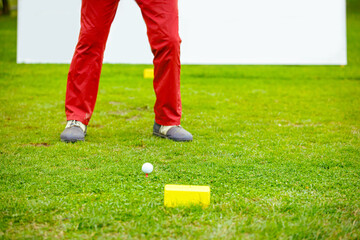Golfer performs a strong golf shot to fairway