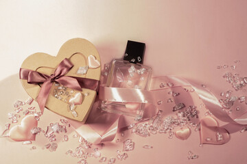 A heart-shaped gift box made of kraft cardboard with a perfume bottle, decorative hearts, and rhinestones. A Valentine's Day gift, wedding gift. Festive backdrop.