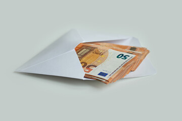 Bundles of banknotes of 50 euros lying in the envelope as a sign of a gift , isolated