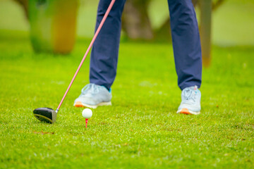 Golfer performs a strong golf shot to fairway