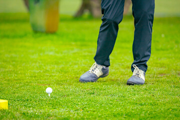 Golfer performs a strong golf shot to fairway