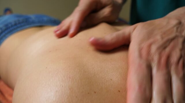 Skilled hands performing a soothing massage on a bare back, showcasing the gentle motion and technique involved in relaxation therapy, highlighting the connection between practitioner and client