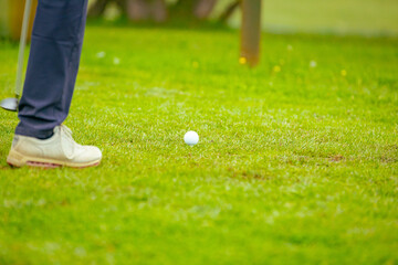 Golfer performs a strong golf shot to fairway