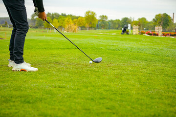 Golfer performs a strong golf shot to fairway