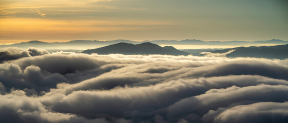 Dramatic cliffs, clouds, soft fog and mountains at sunset, view of Montserrat landscape.