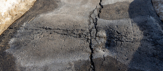 Cracked road with a shadow on it