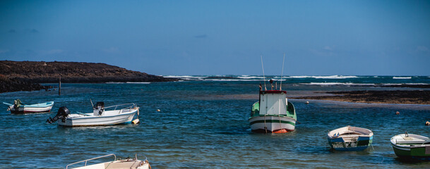 A ocean bay with old fishing boats and motorboats on a sunny day.