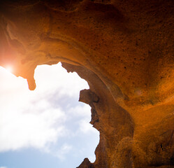 A rock, desert sandy formations, a natural arch Arco de las Penitas in the daylight.