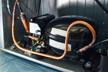 Refrigerator compressor with copper tubing inside appliance, cooling system technology for refrigeration, repair, maintenance and engineering concepts