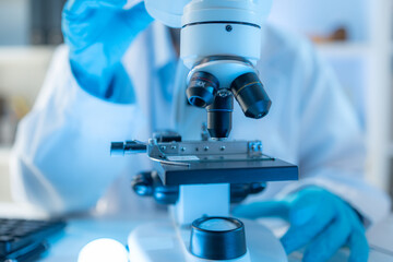 A chemistry researcher in a laboratory surrounded by scientific equipment and test tubes, representing innovation, scientific development, and modern medical research environment.