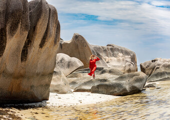 Woman in Red Dress Exploring Ancient Granite Rocks in Seychelles