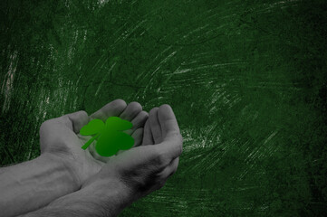 Happy St Patricks Day halftone collage. Hands holding green four leaf clover on green background.