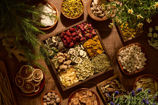 This photo shows a square arrangement of herbal ingredients and wooden trays. The earthy tones and textures support natural food and herbal supplement advertising.