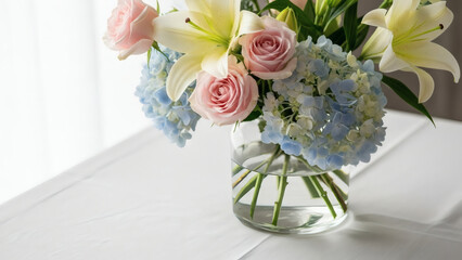 Elegant bouquet of pink roses white lilies and blue hydrangeas in a glass vase on a white table