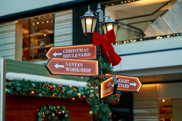 A traditionally decorated old English village signpost at Christmas