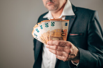Close-up of a businessman offering euro cash, representing money, financial transaction, lending, investment, wealth, or business opportunity.