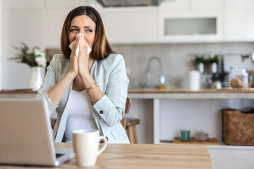 Remote work from home, sneeze and woman with a laptop, sick and illness with fatigue. Female person, freelancer or entrepreneur blowing her nose, virus and flu with online consultation with allergies.