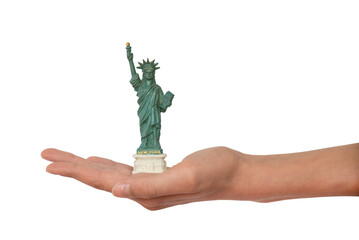 Hand holding a mini Statue of Liberty souvenir figurine from New York, US, miniature statue isolated on white or transparent background, png cut out © Delphotostock