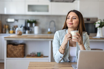 Thinking, planning and working from home on laptop while entrepreneur drinks coffee, tea or hot drink to help concentrate. Freelance blogger or writer with vision ideas, strategy and blog innovation.