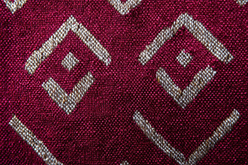 Deep burgundy woven textile pattern ethnic diamond motif silver thread detail fabric texture handcrafted cloth traditional craft rich color closeup macro cultural design elegant weave
